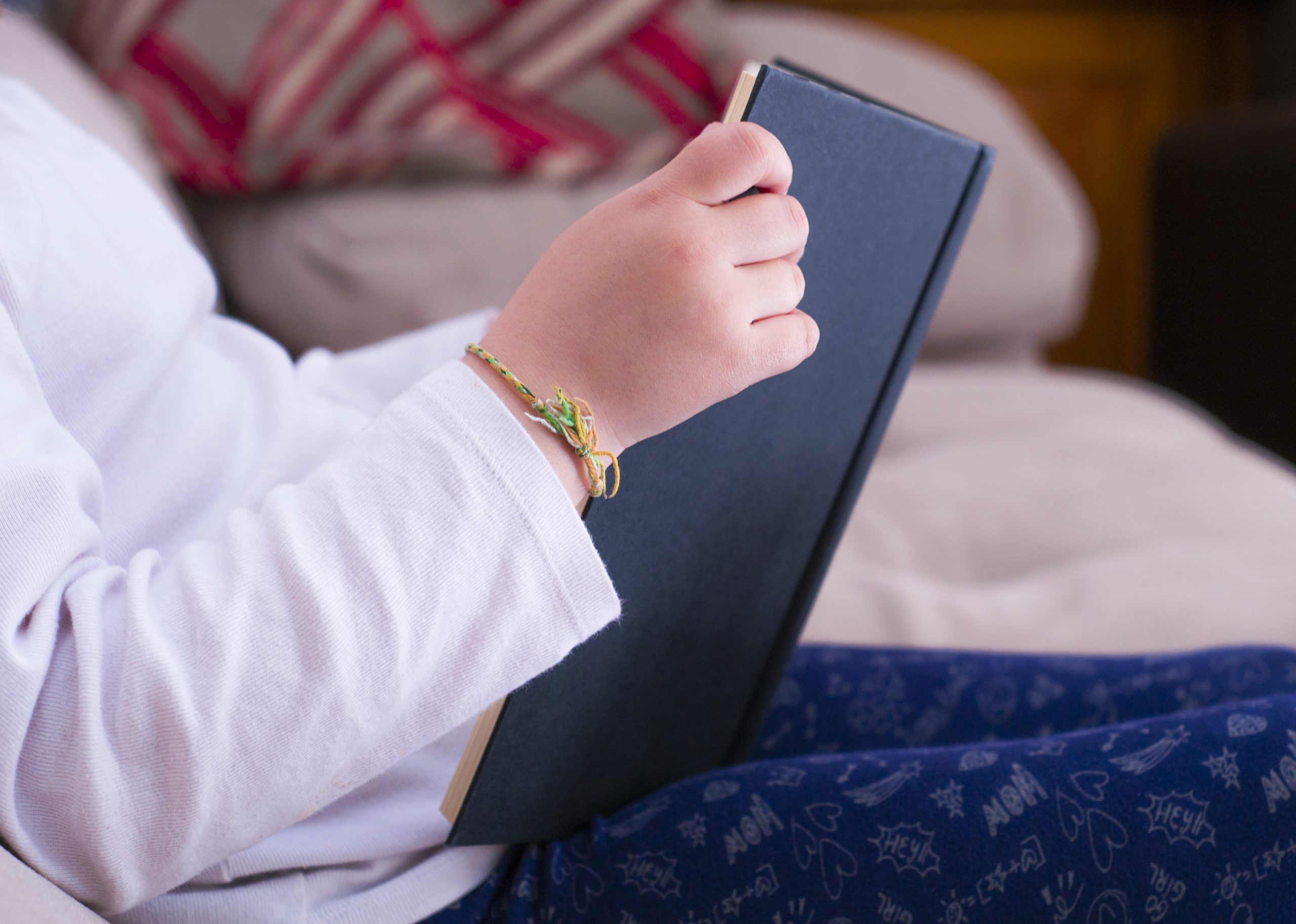 closeup shot of a seated baby reading a book